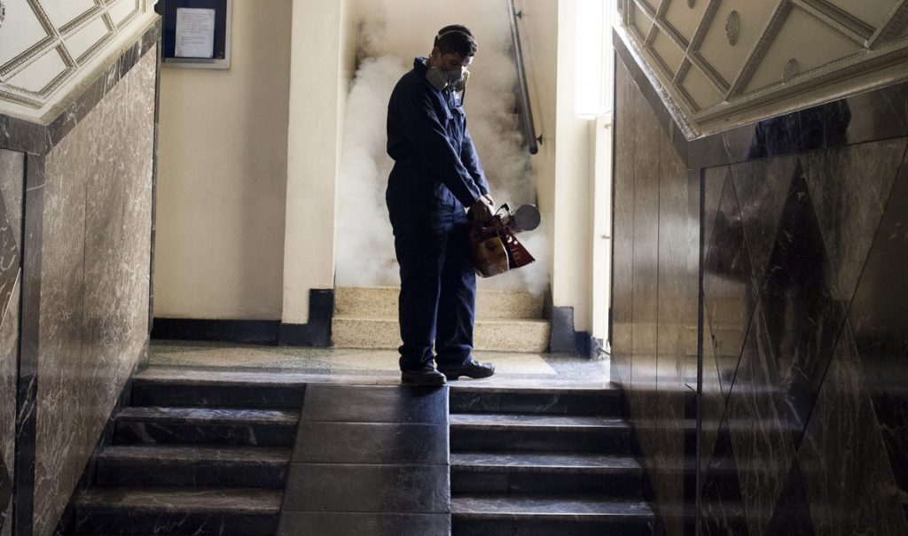 A worker from the Chacao municipality fumigates the hallway of a building to eradicate mosquitoes that can cause the Zika virus, in Caracas, Venezuela.