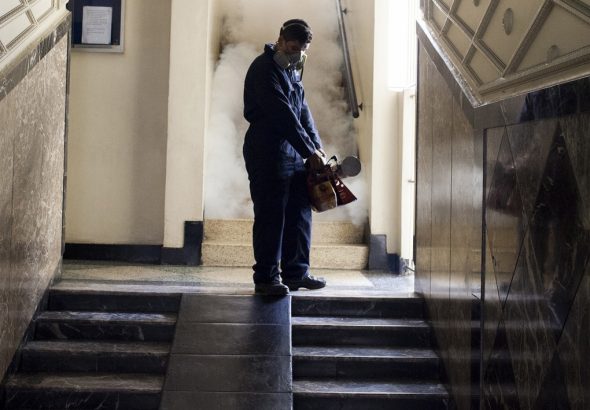 A worker from the Chacao municipality fumigates the hallway of a building to eradicate mosquitoes that can cause the Zika virus, in Caracas, Venezuela.